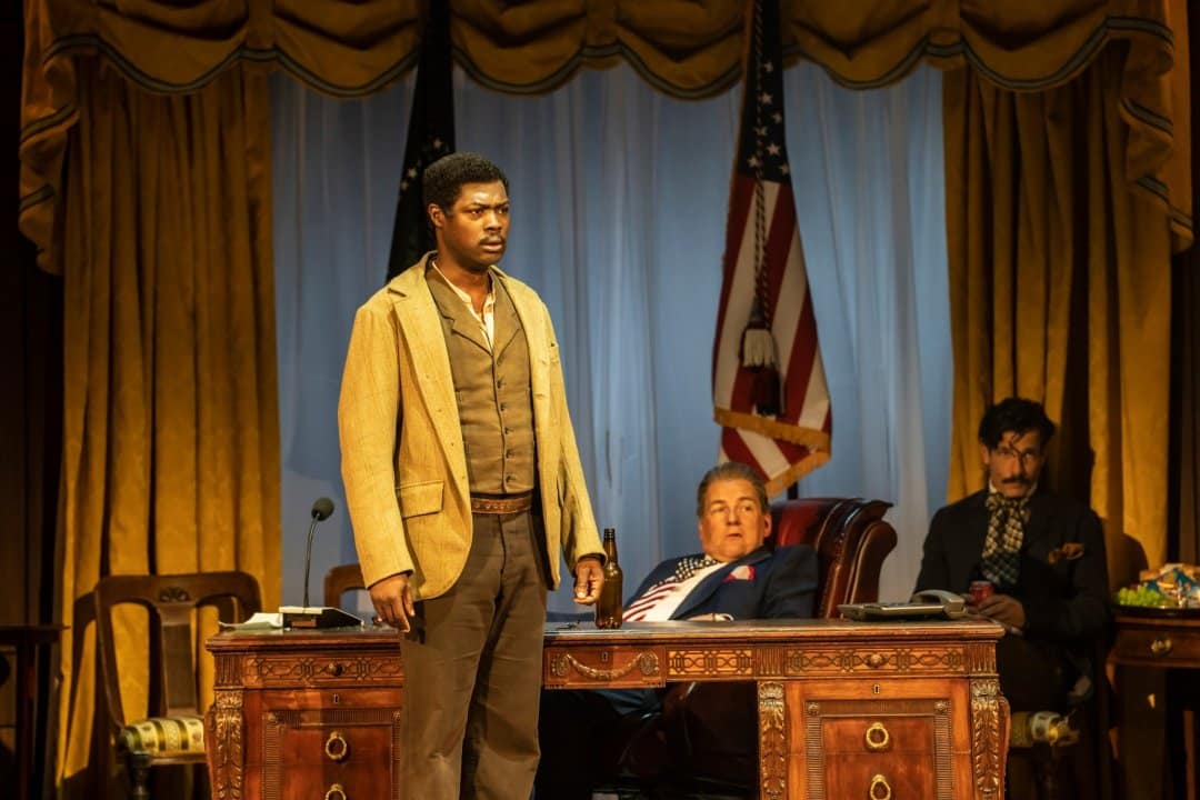 Sam-Oladeinde-as-Leon-Czolgosz-Peter-Forbes-The-Proprietor-Danny-Mac-John-Wilkes-Booth-in-CFTs-Assassins-Photo-by-Johan-Persson Sam-Oladeinde-as-Leon-Czolgosz-Peter-Forbes-The-Proprietor-Danny-Mac-John-Wilkes-Booth-in-CFTs-Assassins-Photo-by-Johan-Persson