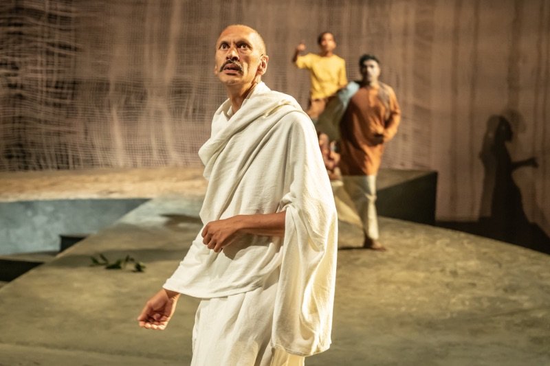 Paul-Bazely-Mohandas-Gandhi-and-company-in-The-Father-and-the-Assassin-at-the-National-Theatre-2023.-Credits-Marc-Brenner Paul-Bazely-Mohandas-Gandhi-and-company-in-The-Father-and-the-Assassin-at-the-National-Theatre-2023.-Credits-Marc-Brenner