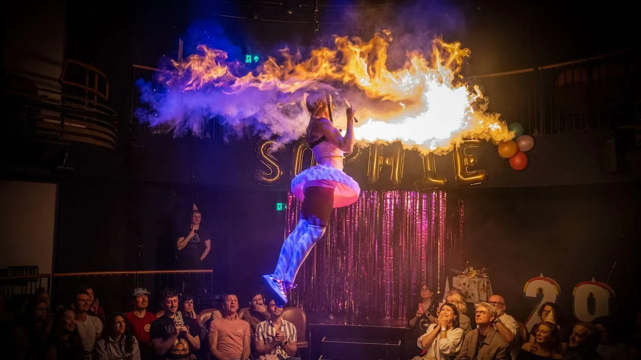 Woman hanging from roof surrounded by fire. Sophie's Surprise 29th, Underbelly Boulevard