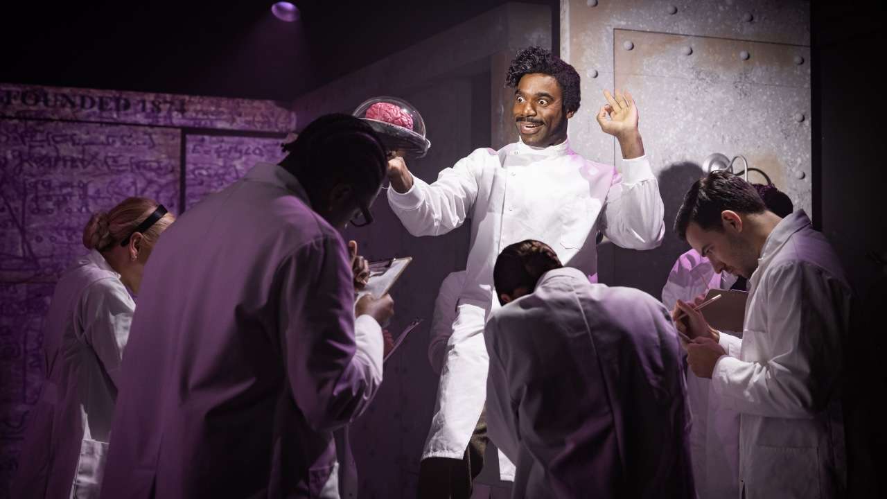Ore Oduba back as Dr Frederick Frankenstein holding a braing in Young Frankenstein the musical