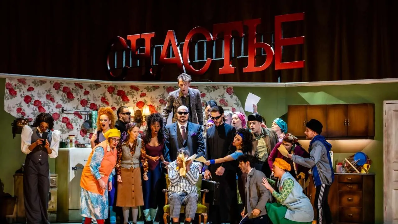 Vibrant ensemble cast gathers on stage in this colourful West End comedy production, with bold set design and elaborate costume pieces creating theatrical mayhem.